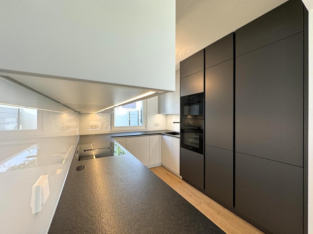 Designerküche mit Steinplatte und Geräte von Miele