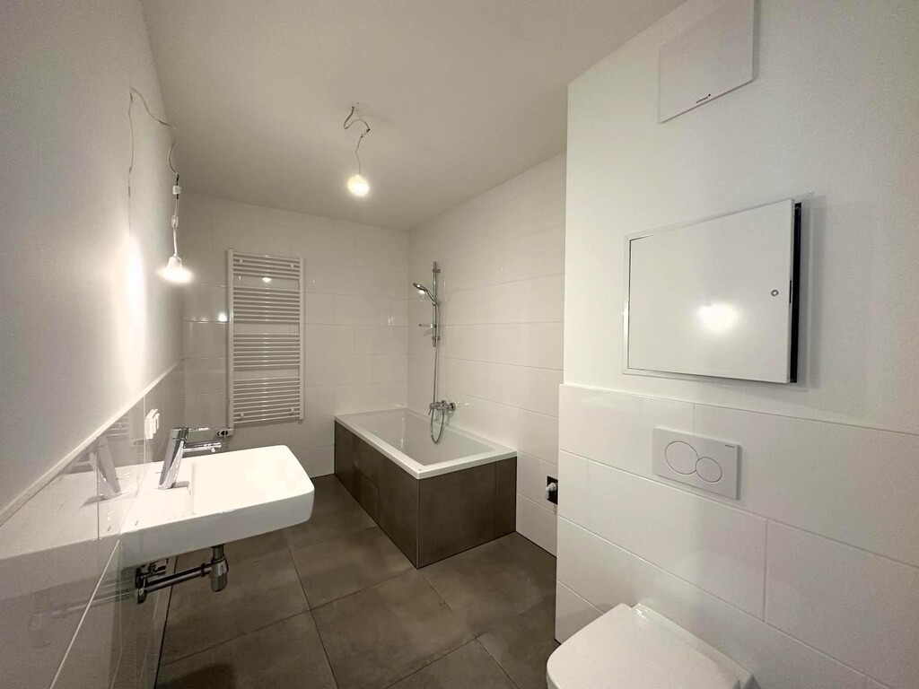 Badezimmer mit Badewanne, Toilette und WM-Anschlus