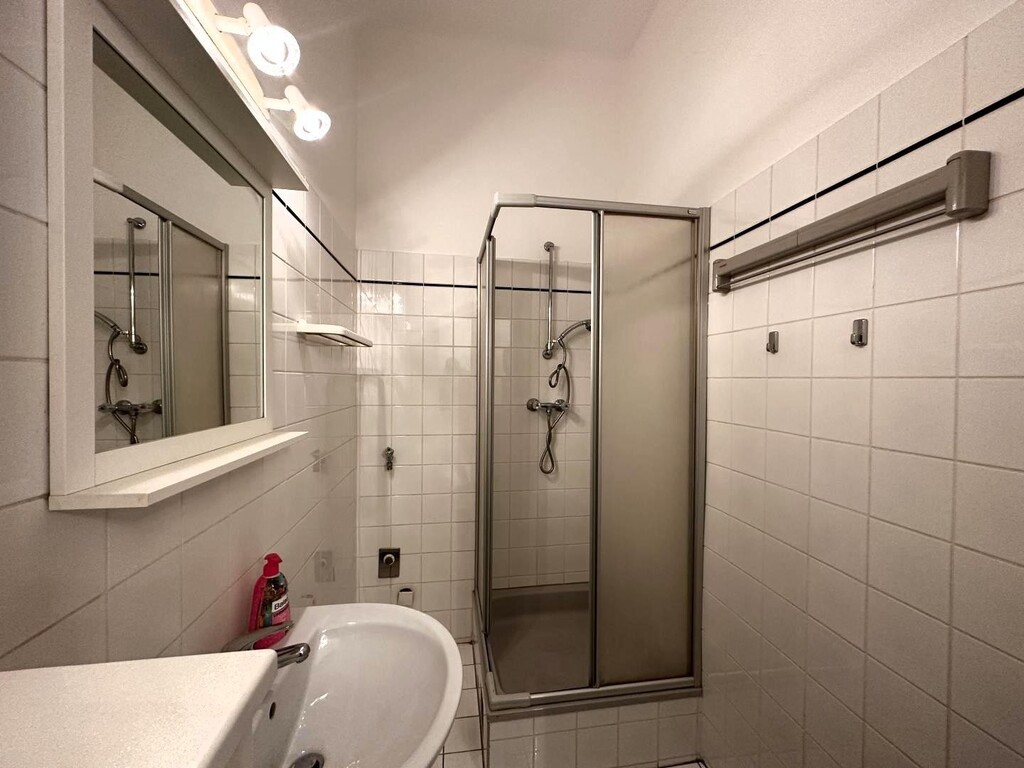 Badezimmer mit Dusche, Waschbecken und WM-Anschlus